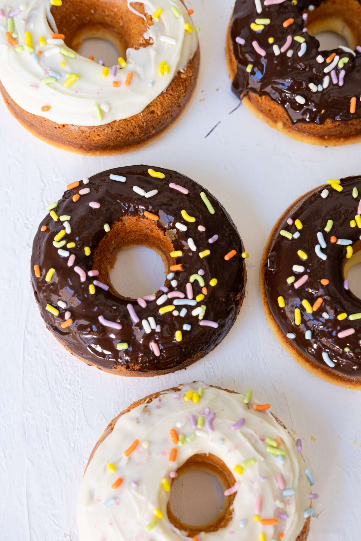 White and milk chocolate glazed baked donuts. 