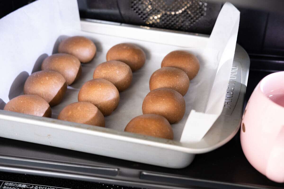 Shape the milk buns and let them rise in the oven with a cup of hot water aside. 